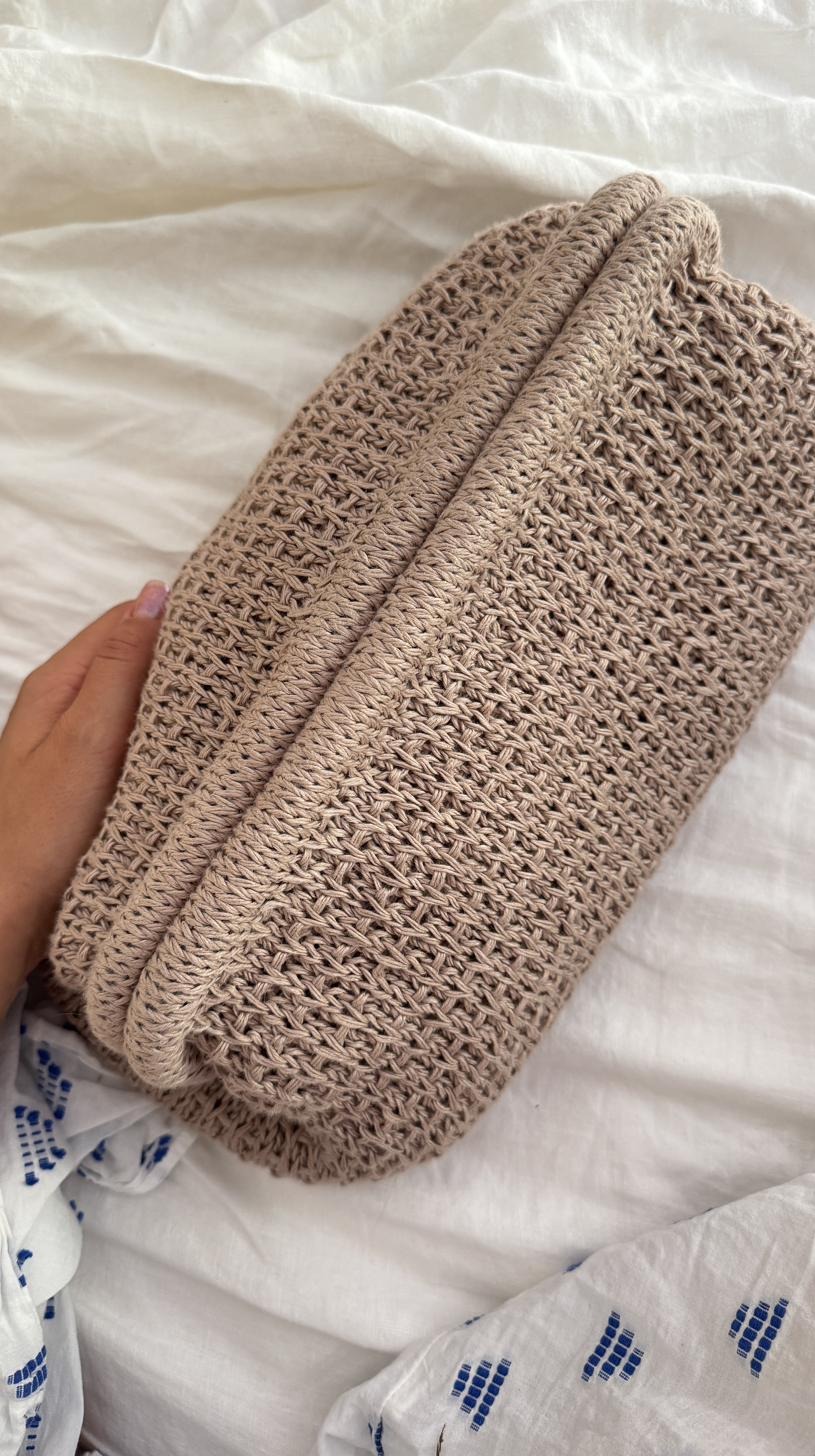 Beige crocheted clutch bag with an open mesh texture